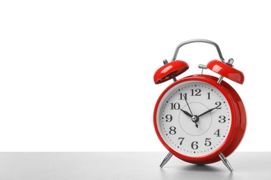 Photo of Alarm clock on table against white background. Time concept