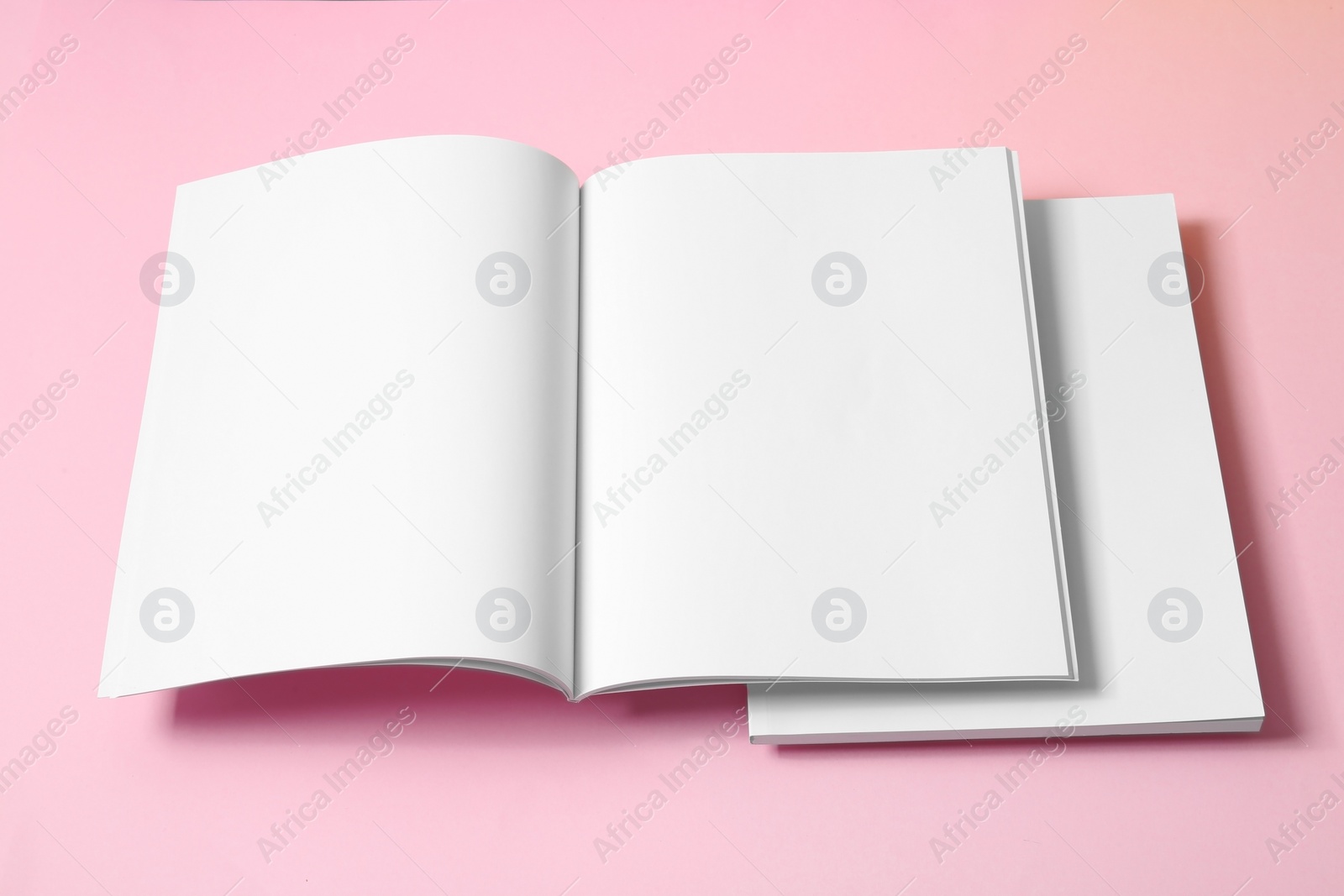 Photo of Empty book pages on pink background. Mockup for design