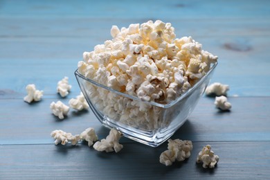 Photo of Tasty popcorn on light blue wooden table