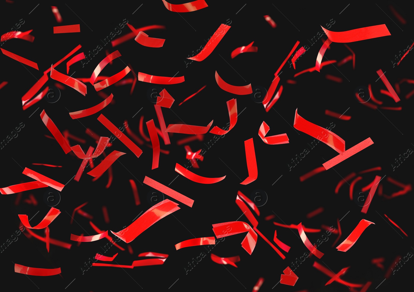 Image of Shiny red confetti falling down on black background