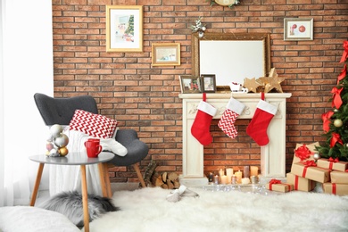 Photo of Room interior with beautiful Christmas tree and gifts near decorative fireplace