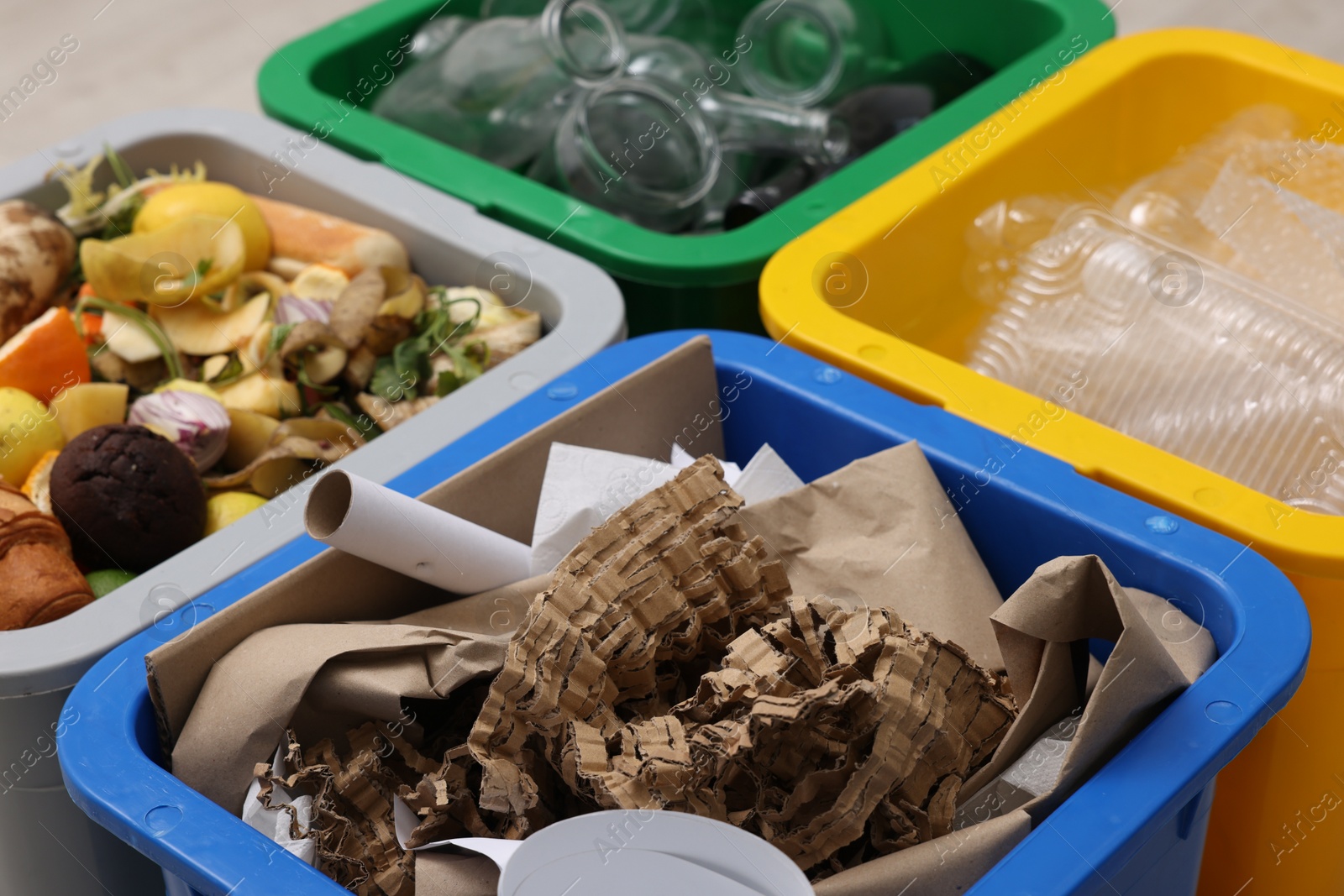 Photo of Garbage sorting. Full trash bins for separate waste collection indoors, closeup