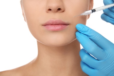 Young woman getting facial injection on white background, closeup. Cosmetic surgery concept