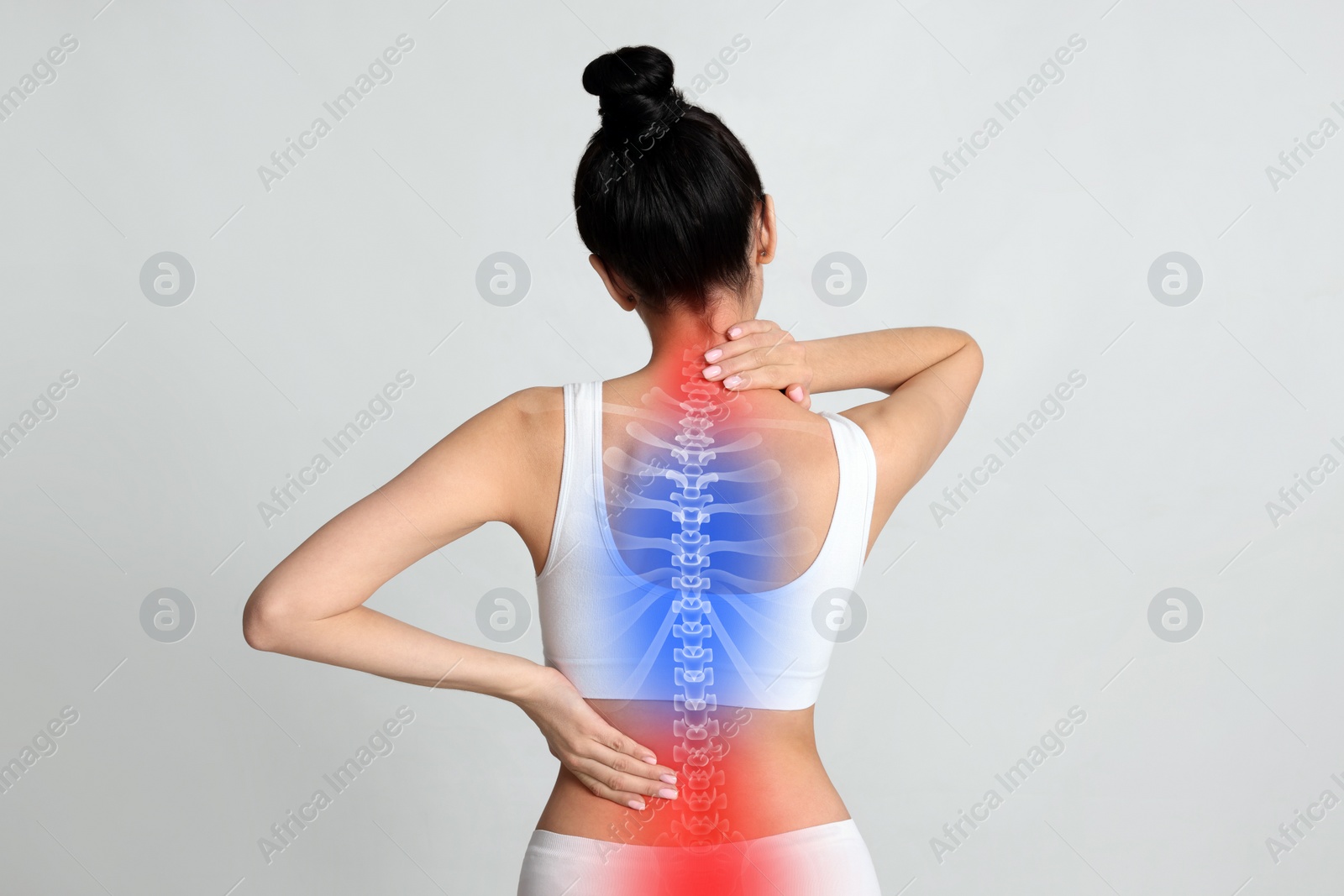 Image of Woman suffering from pain in back on light background