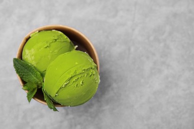 Photo of Paper cup with tasty matcha ice cream on grey table, top view. Space for text