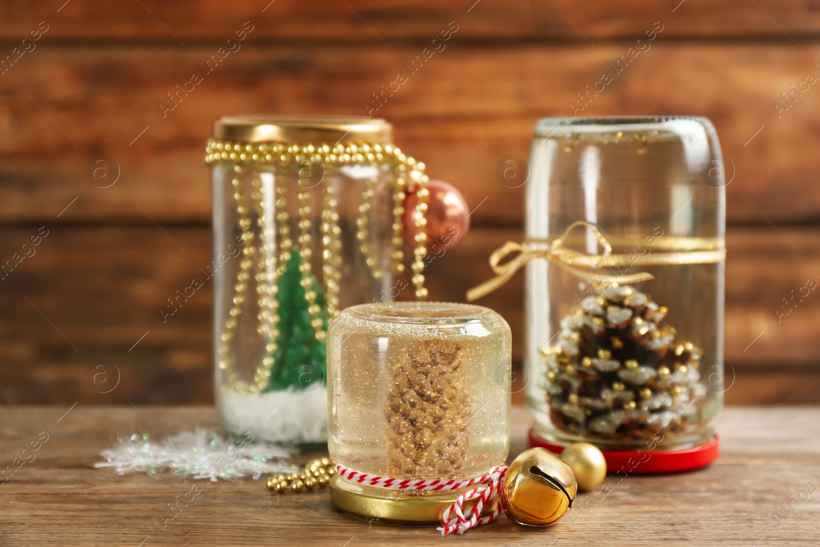 Photo of Handmade Christmas snow globes on wooden table