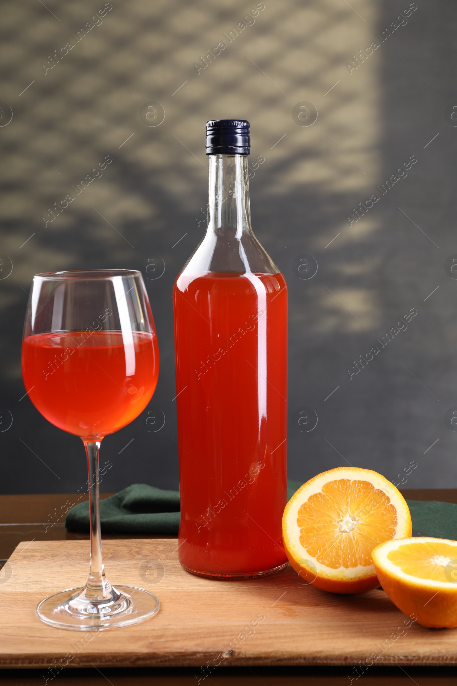 Photo of Aperol spritz cocktail in glass and bottle on wooden table