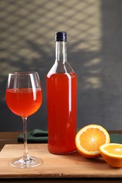 Aperol spritz cocktail in glass and bottle on wooden table