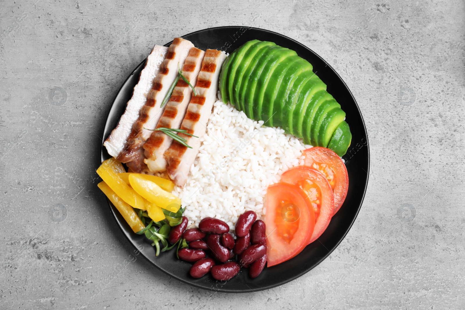 Photo of Delicious rice with beans and meat on grey table, top view