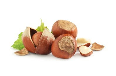 Photo of Tasty organic hazelnuts and leaves on white background