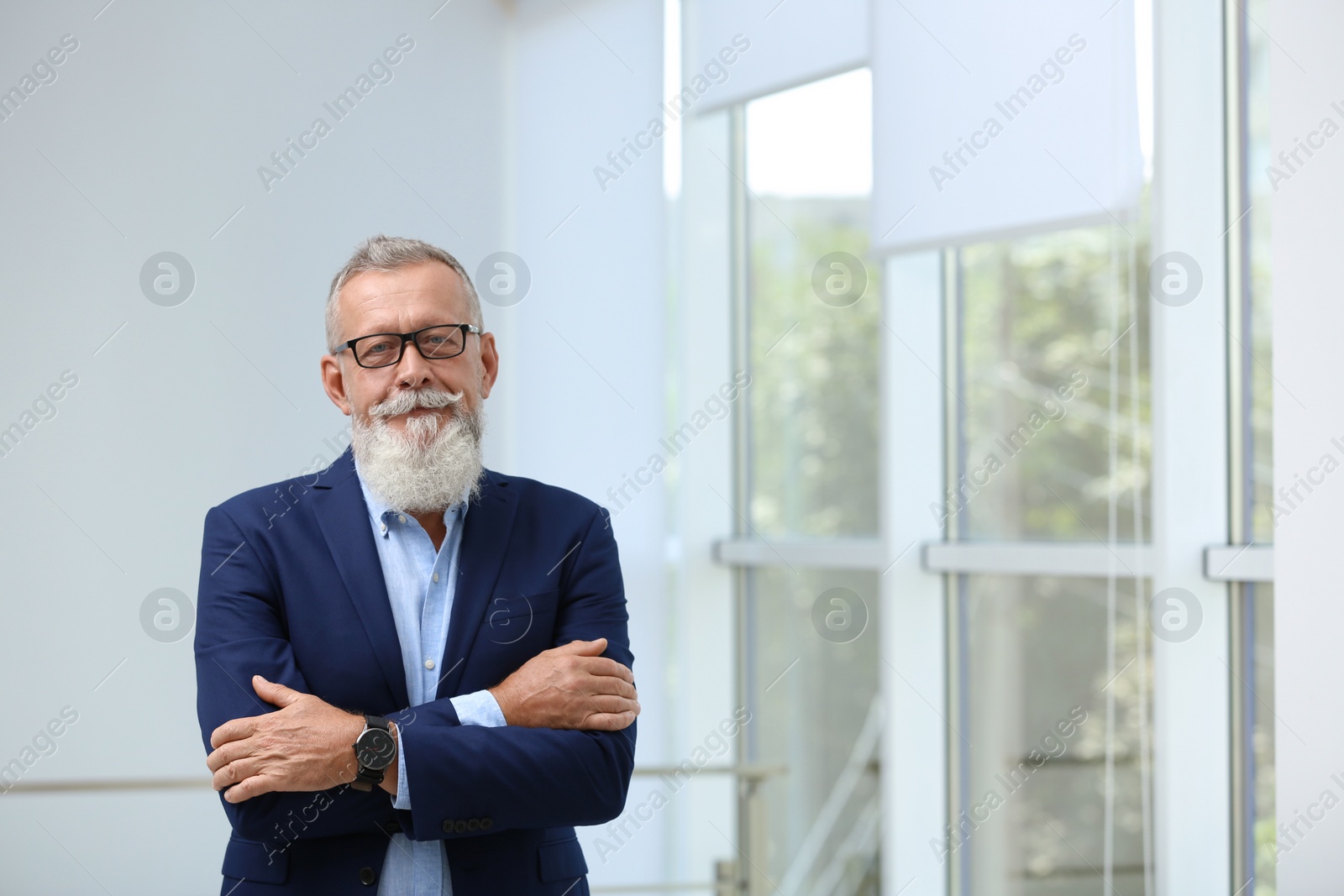 Photo of Portrait of handsome mature man in elegant suit with glasses indoors