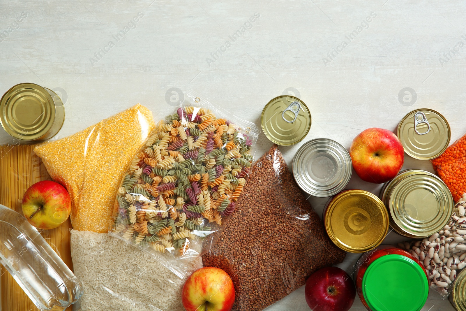 Photo of Many different products and space for text on white wooden background, flat lay. Food donation