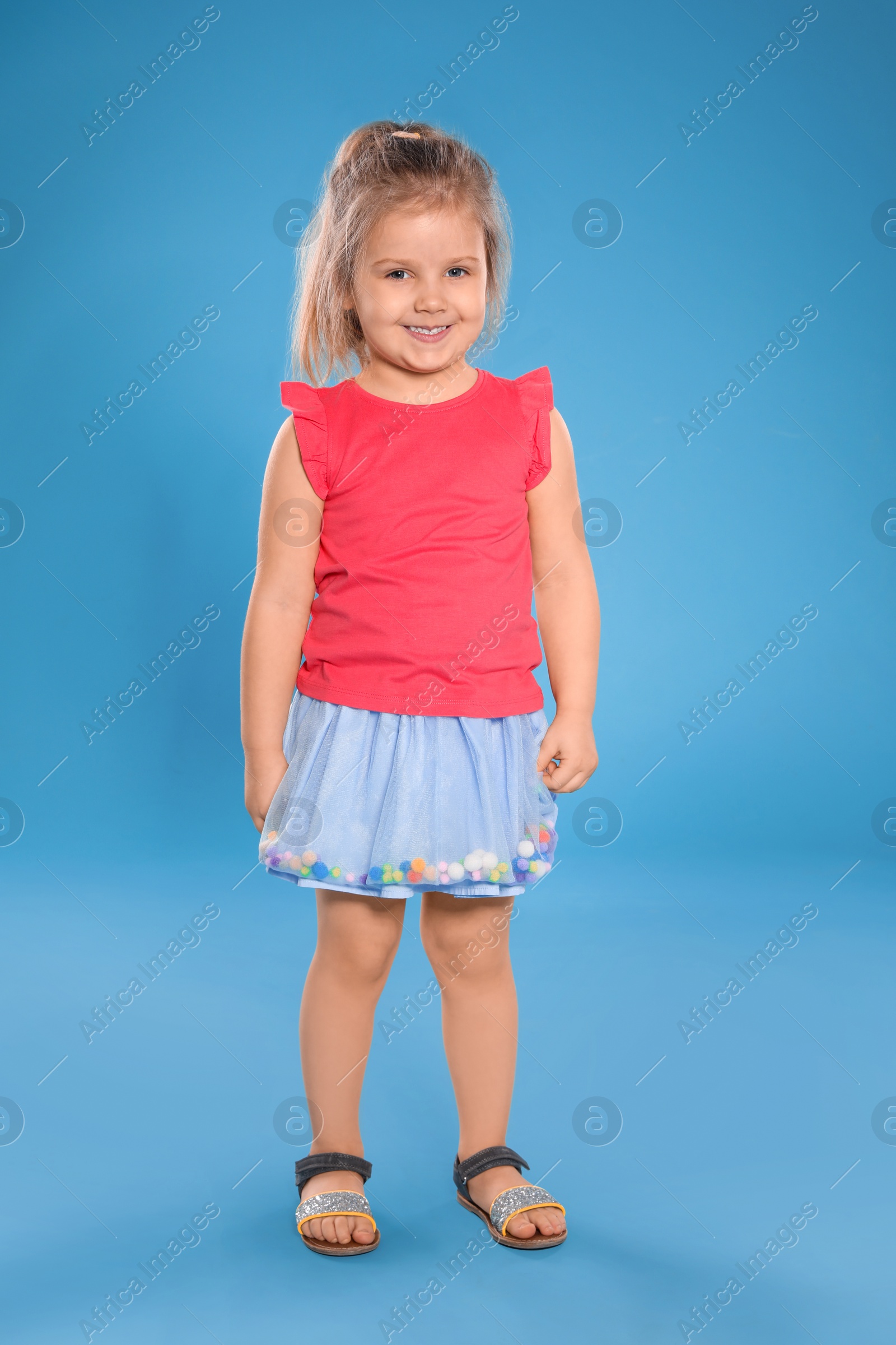 Photo of Full length portrait of cute little girl against color background