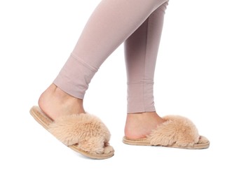 Photo of Woman in beige fluffy slippers on white background, closeup