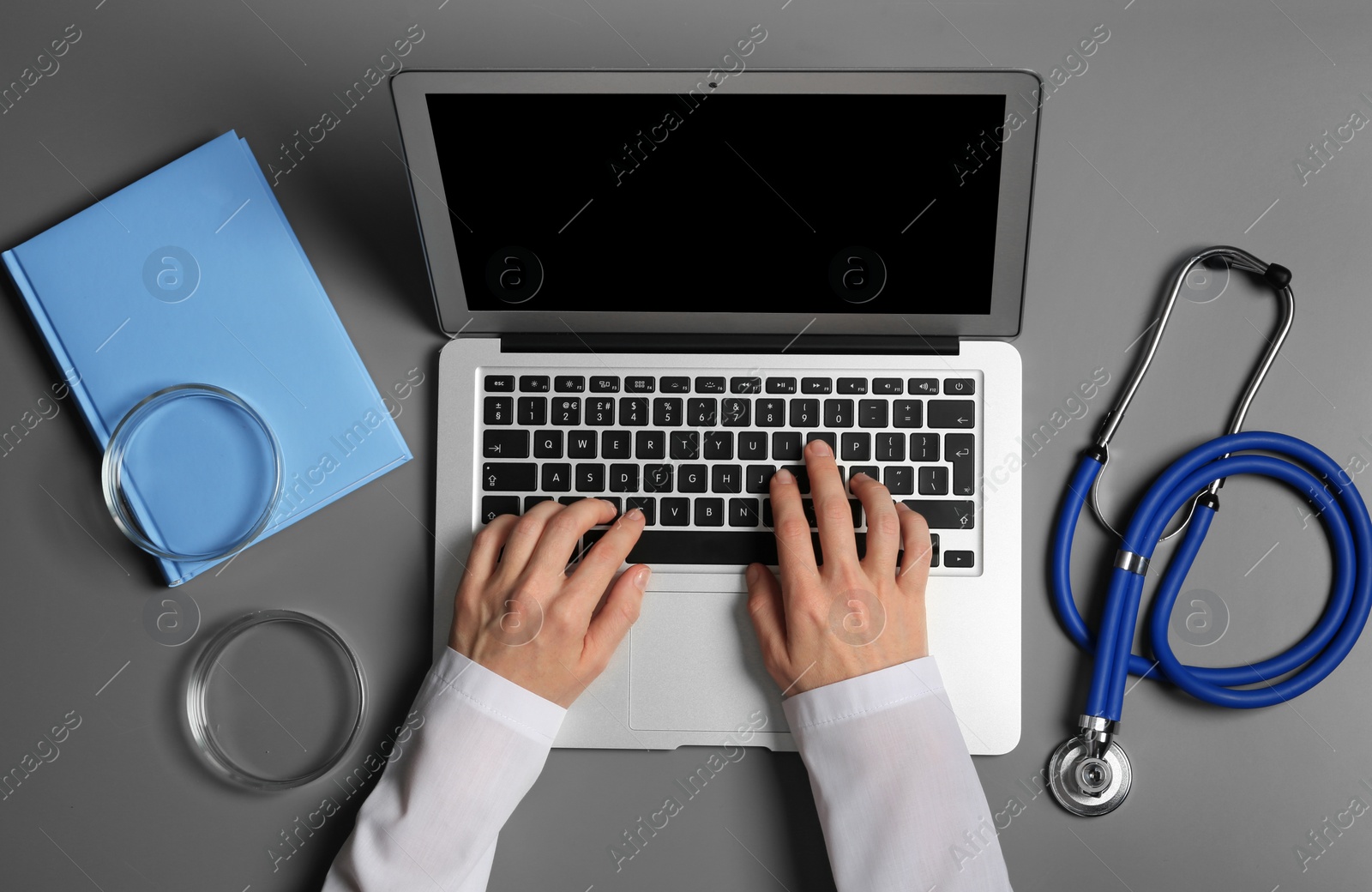 Photo of Student with modern laptop and medical stuff at table, top view