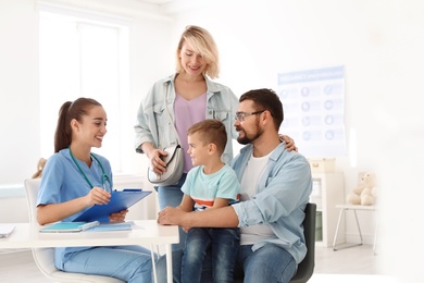 Photo of Little boy with parents visiting children's doctor in hospital