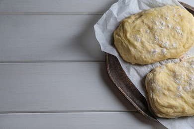 Raw dough and flour on white wooden table, space for text. Cooking ciabatta