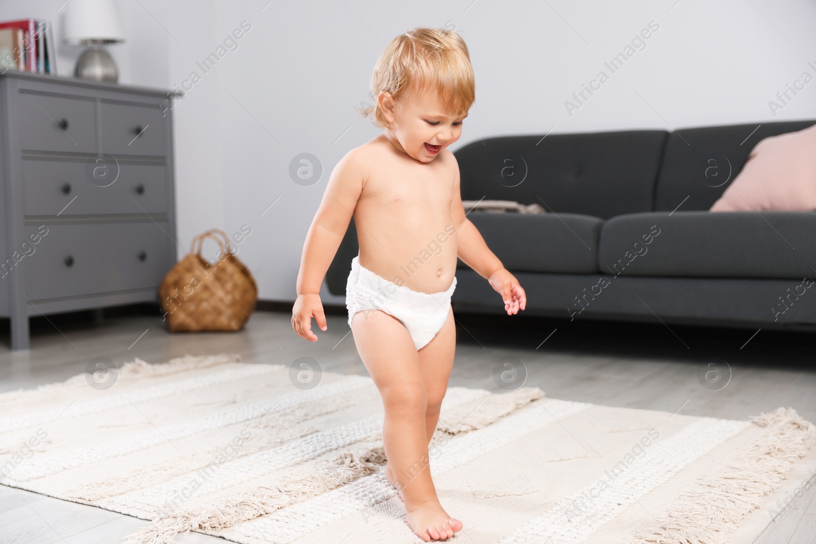 Photo of Cute baby learning to walk in living room