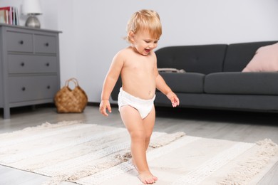 Cute baby learning to walk in living room