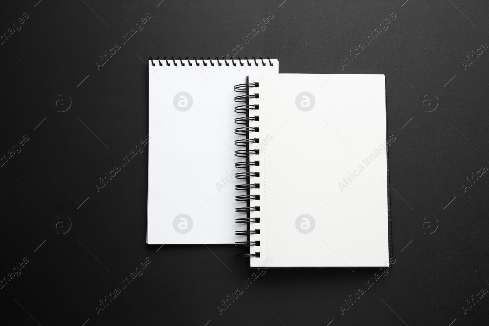 Photo of Two notebooks on black background, top view