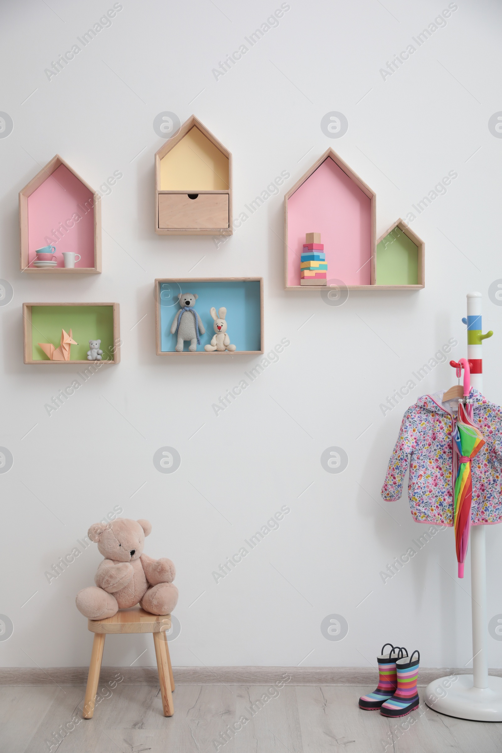 Photo of Stylish baby room interior design with house shaped shelves and coat rack