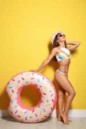 Photo of Beautiful young woman with inflatable ring near color wall