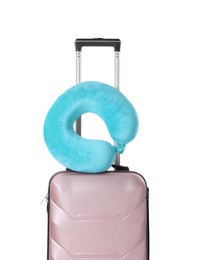 Light blue travel pillow on suitcase against white background