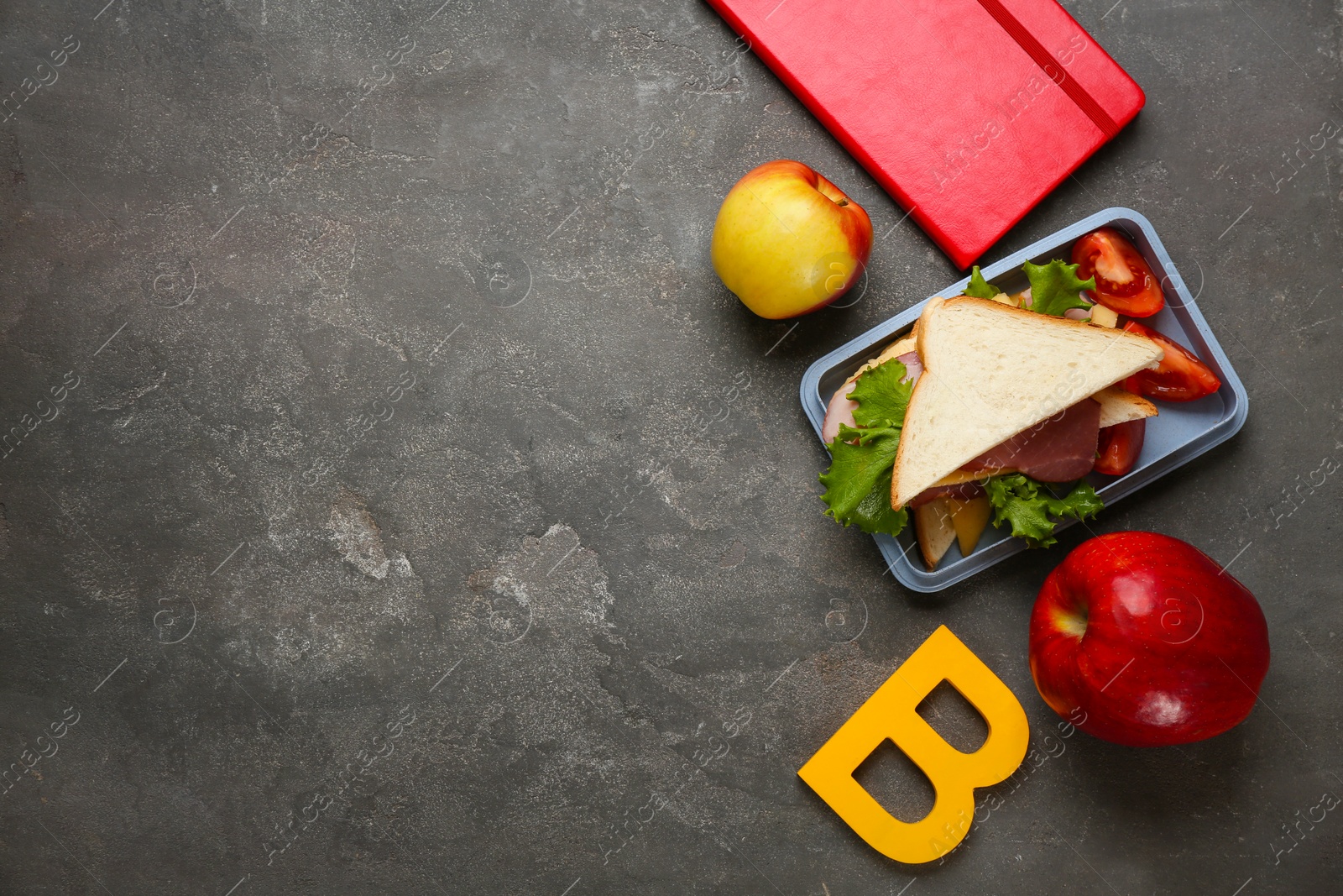 Photo of Flat lay composition with lunch box and appetizing food for school on grey background