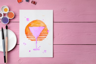 Photo of Flat lay composition with watercolor painting of martini glass and paints on pink wooden table. Space for text