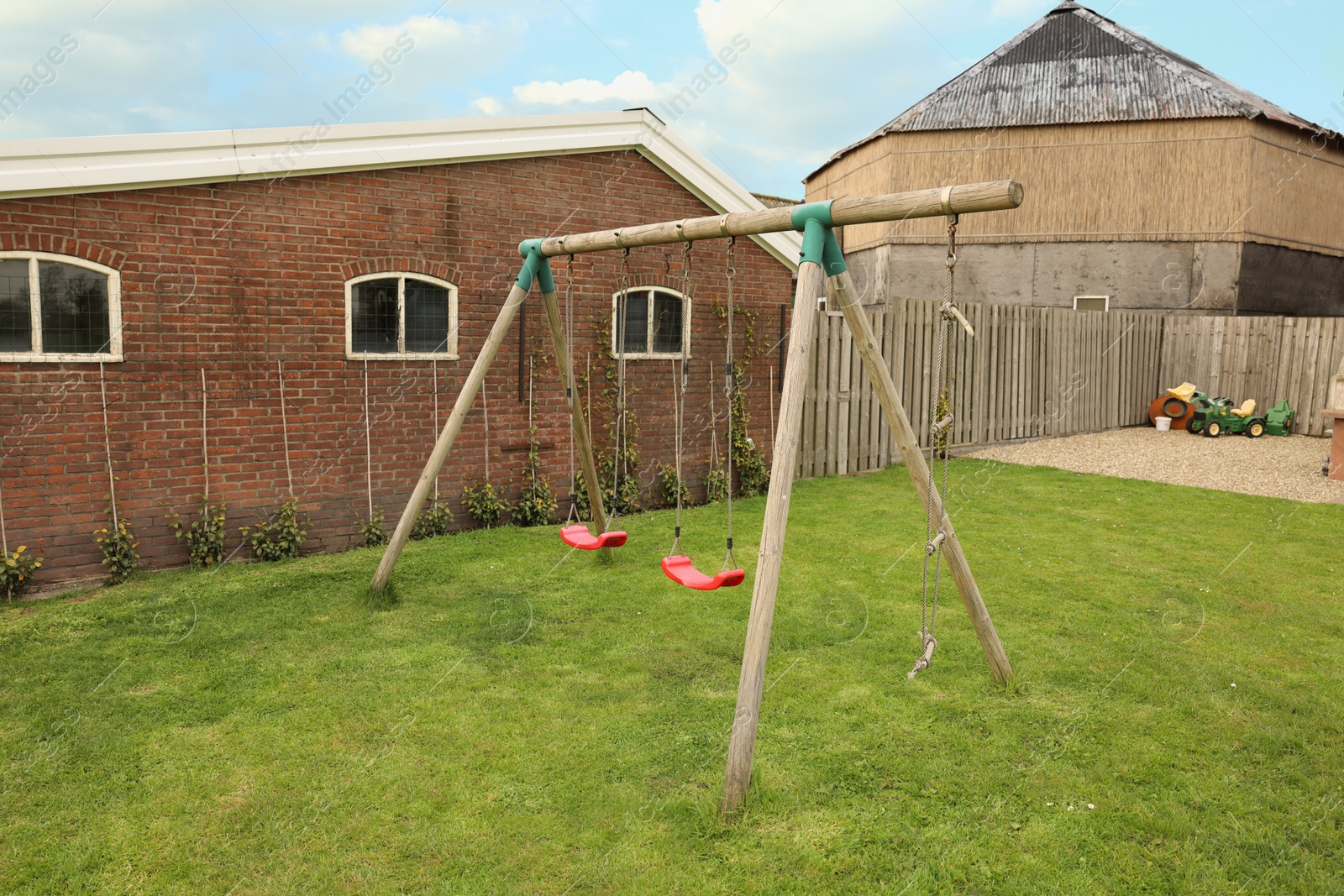 Photo of Spacious backyard with swing set on spring day