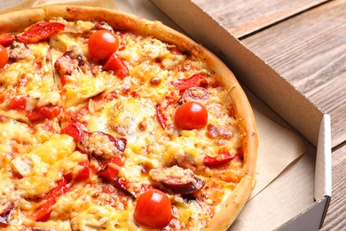 Cardboard box with delicious pizza, closeup