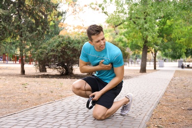 Young man having heart attack while running in park