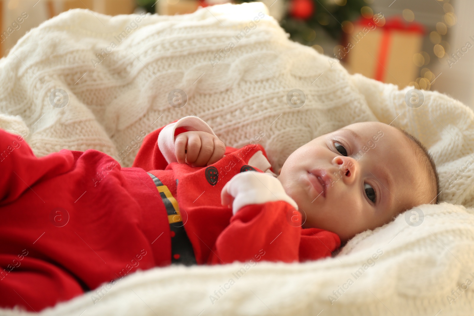 Photo of Cute little baby in Christmas costume on knitted blanket