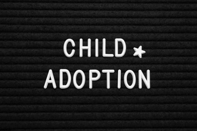 Photo of Phrase Child Adoption on black letter board, flat lay