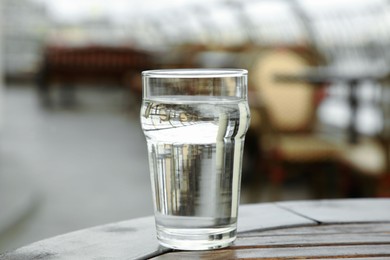 Photo of Glass of fresh water on table outdoors, closeup
