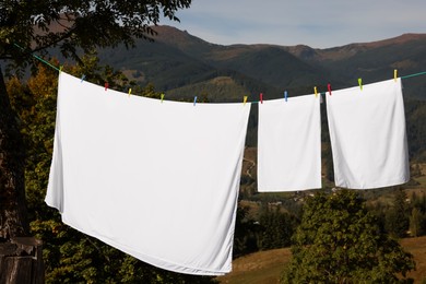 Photo of Laundry with clothes pins on line outdoors