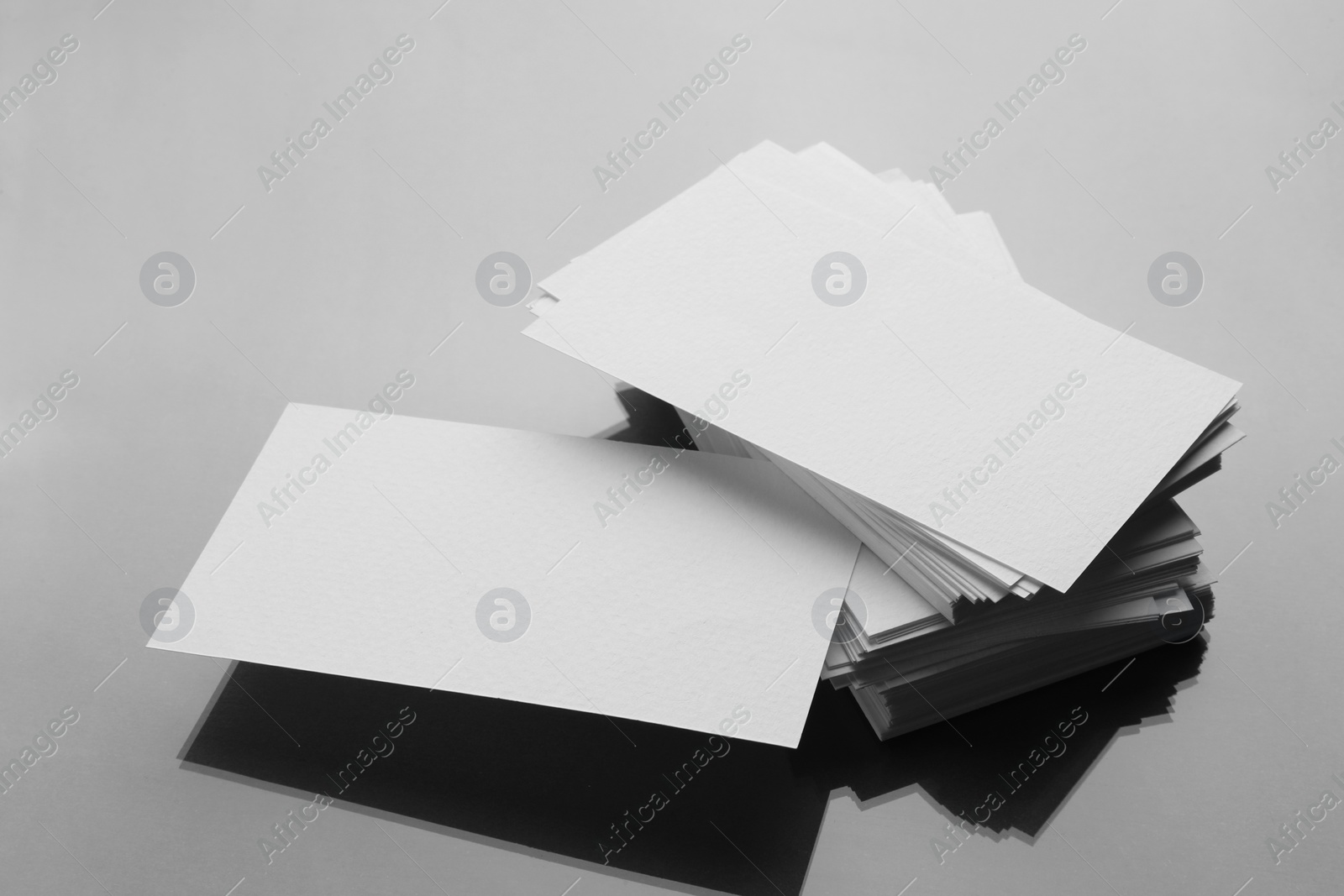 Photo of Blank business cards on mirror surface. Mockup for design