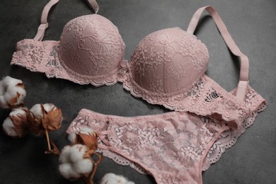 Photo of Elegant light pink women's underwear and cotton flowers on grey background