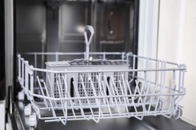 Photo of Open clean empty dishwasher in kitchen, closeup