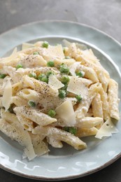 Photo of Delicious pasta with green peas, cheese and creamy sauce on grey table