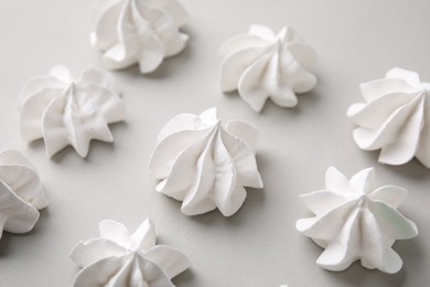 Photo of Tasty meringue cookies on light grey background, closeup