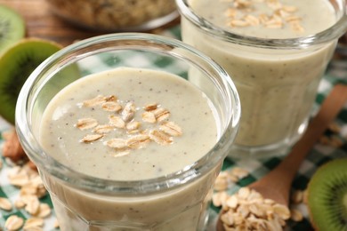 Tasty kiwi smoothie with oatmeal on table, closeup