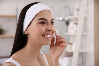 Photo of Woman using silkworm cocoon in skin care routine at home