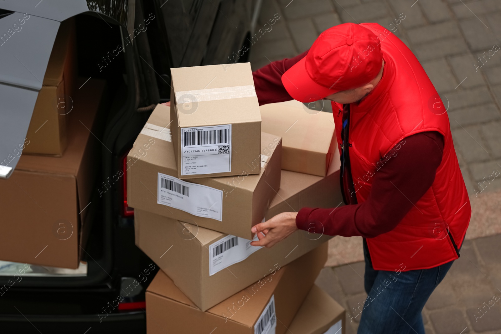 Photo of Courier with parcels near delivery van outdoors, above view