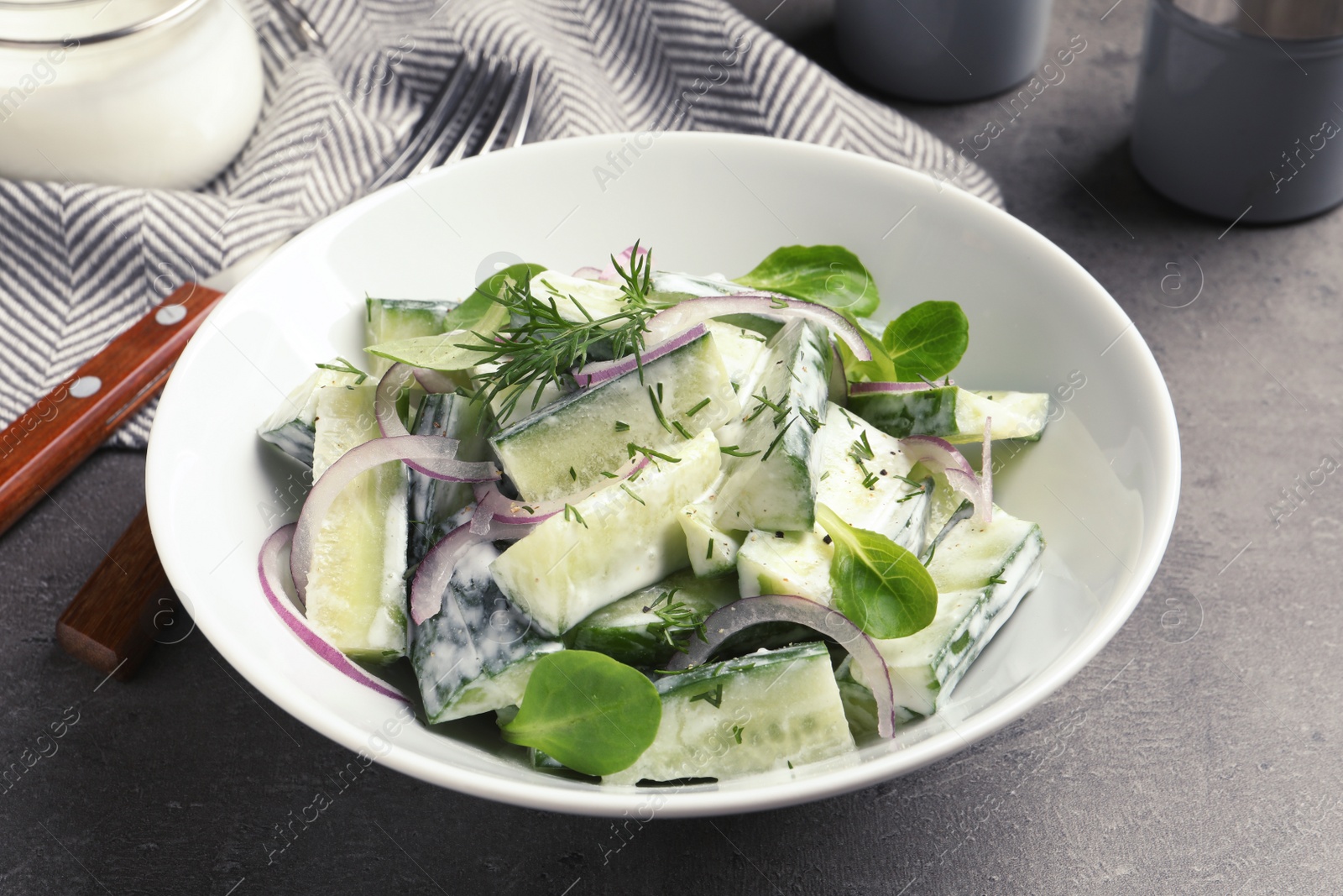 Photo of Plate with creamy cucumber salad served on table