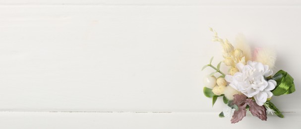 Photo of Beautiful boutonniere on white background, top view. Space for text