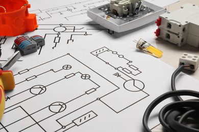 Photo of Wiring diagrams and different electrician's equipment on white table