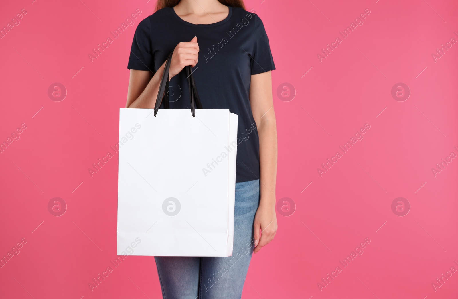 Photo of Woman with paper shopping bag on color background. Mock up for design