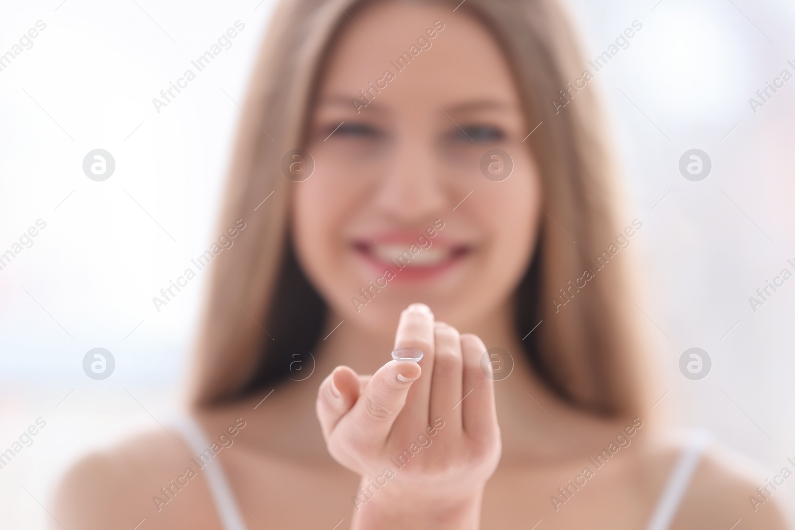 Photo of Woman holding contact lens, closeup