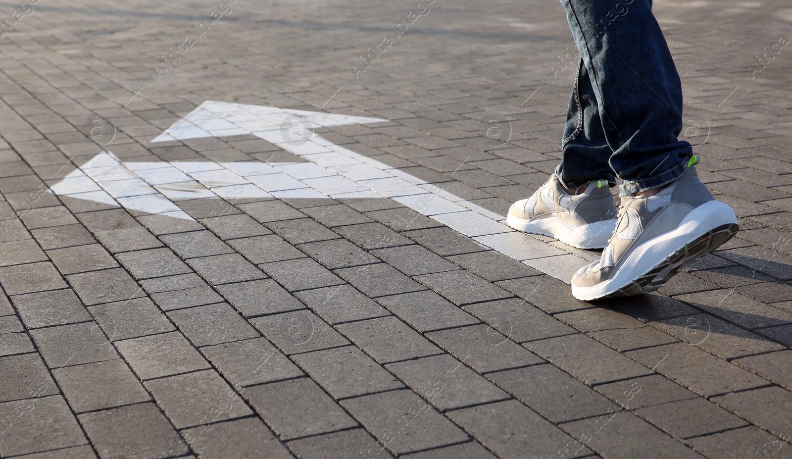 Photo of Man going along road with arrows marking, closeup